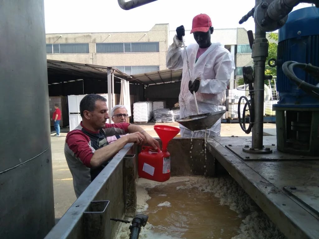Operarios dosificando tratamiento en aguas residuales industriales